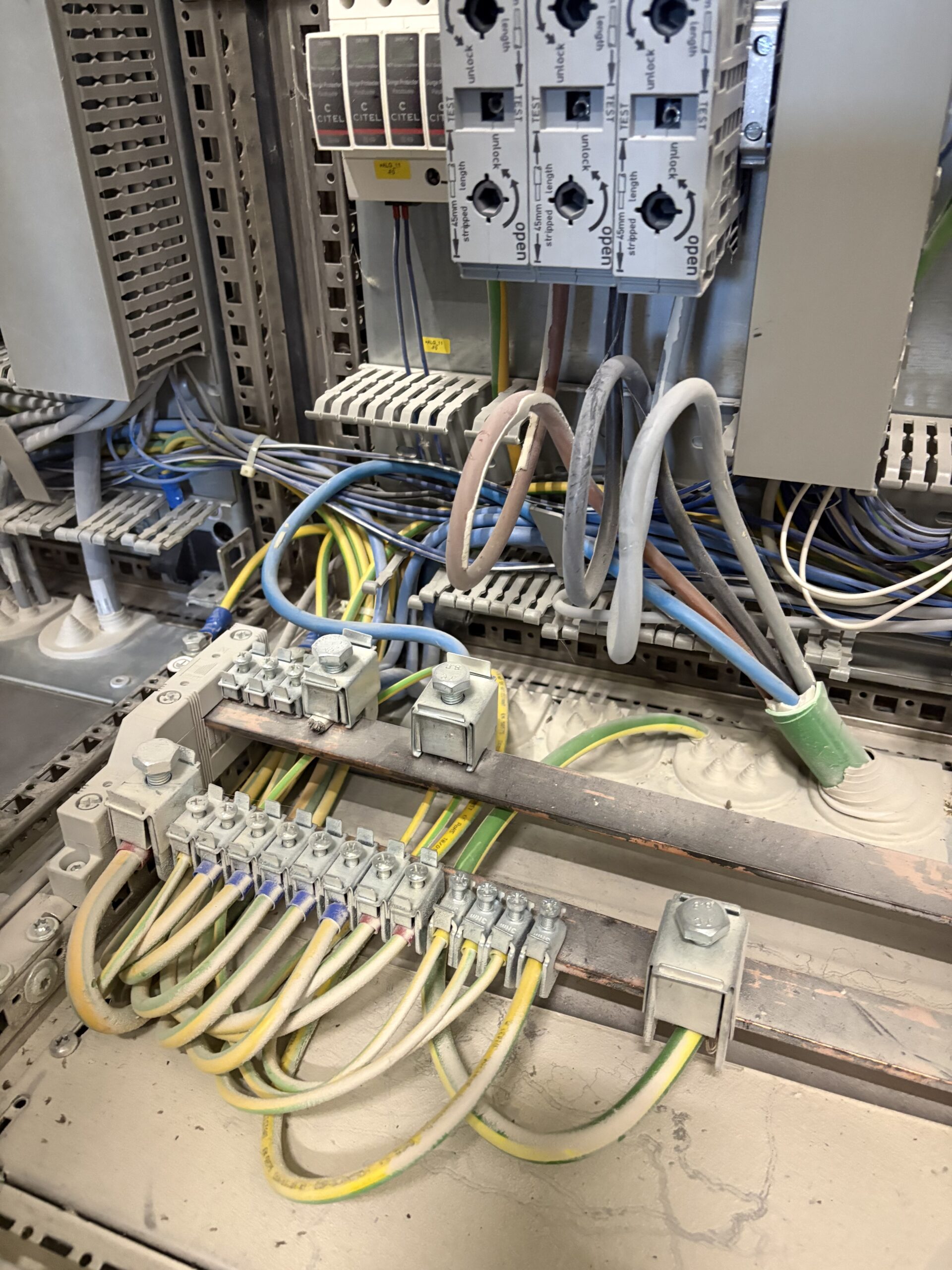 Bornier de terre couvert de dépôts avant dépoussiérage de l'armoire électrique
