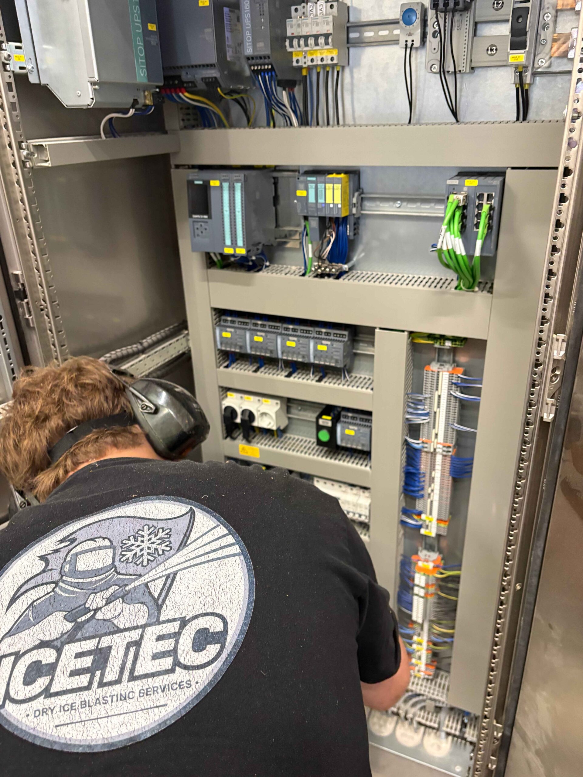 Technicien Icetec intervenant dans une armoire électrique industrielle